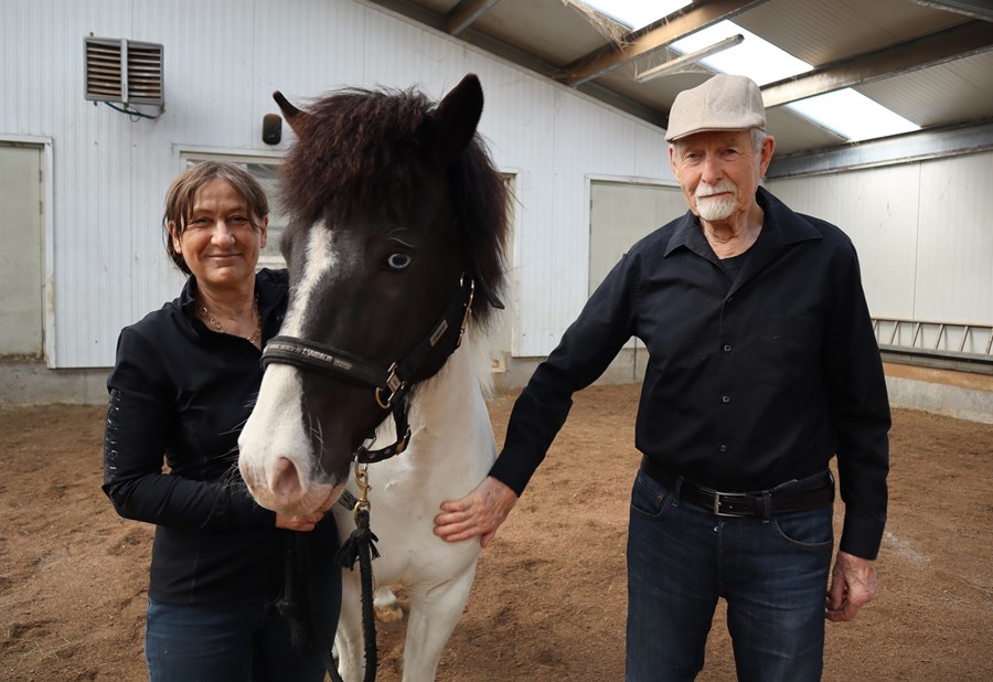 Marietta Maissen og Pétur Behrens í reiðhöll sinni að Finnsstaðaholti, með hryssunni Blábrá frá Finnsstaðaholti, undan Aski frá Finnsstaðaholti og Hrannarsdótturinni Sunnu frá Keldnakoti. Þau hafa lagt æviverkið í kynbótastarf og tamningar auk þess að vera bæði myndlistarmenn.