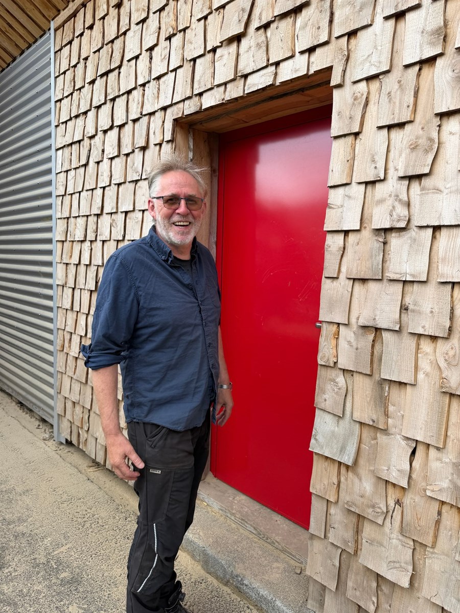 Einar fyrir utan timburklædda verksmiðju Tandrabrettis á Eskifirði. 