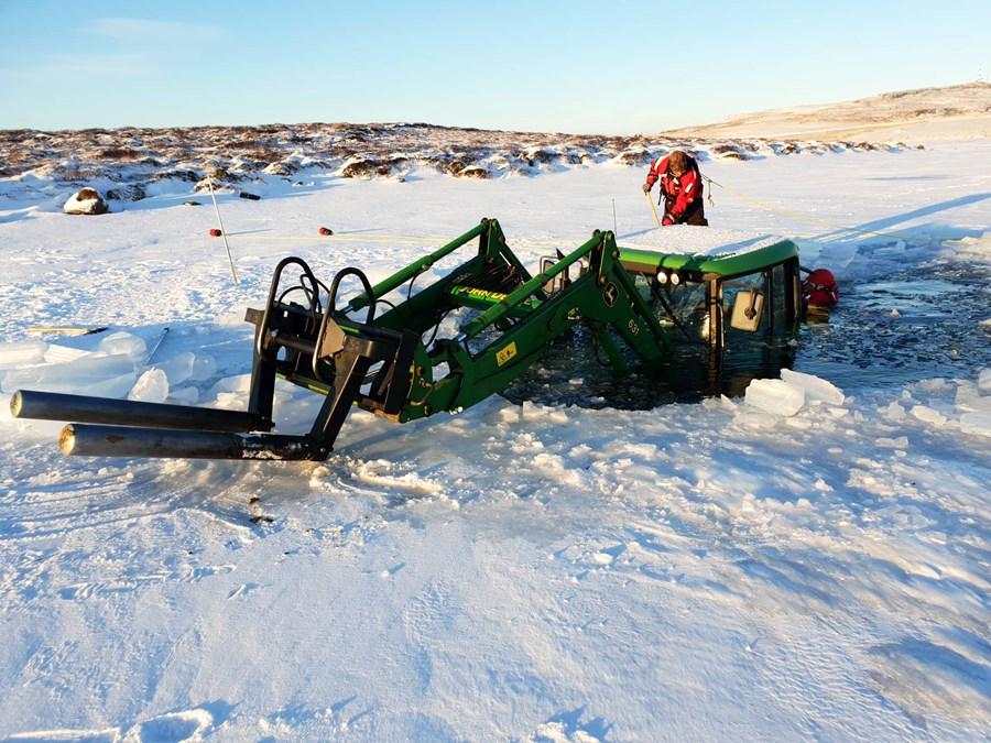 Dráttarvél fór niður um ís og bóndinn skreið út um afturrúðuna