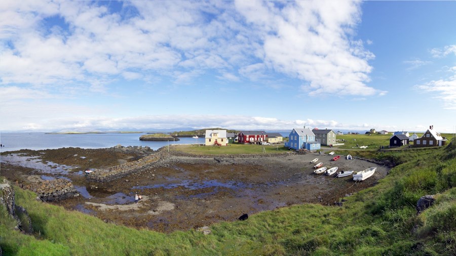 Gamla bátalagið í Þýskuvör og Stórigarður, sem Björn Sigurðsson kaupmaður lét hlaða til skjóls fyrir bátana um aldamótin 1900. Við voginn stendur og þorpið í Flatey, en í baksýn má sjá Höfnina sem er skeifulaga klettaeyja sem var aðalskipalægið við Flatey