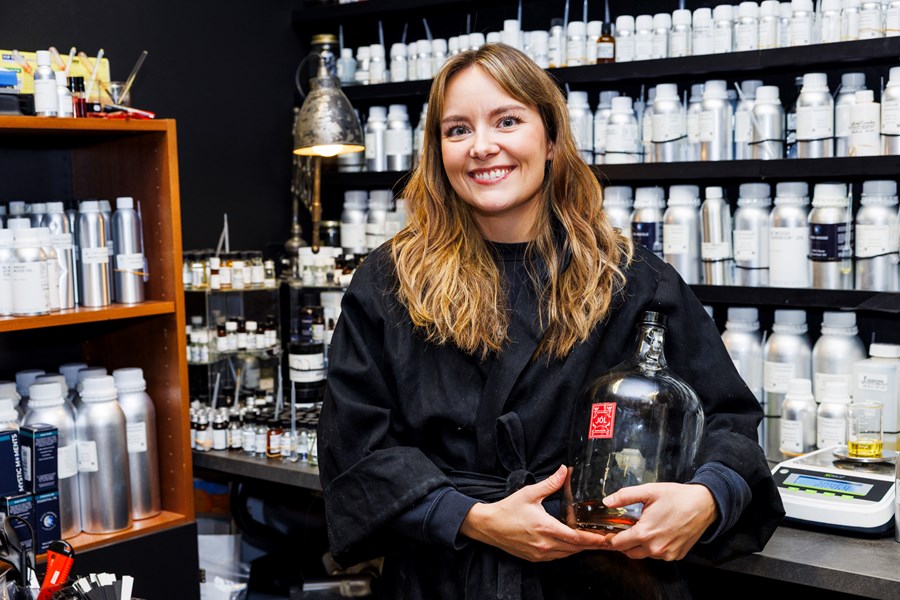 Sigurrós Birgisdóttir er ein systkinanna sem standa á bak við ilmgerðina Fischersund. Hér situr hún við aðstöðu þar sem hún getur þróað og framleitt ilm. Hún heldur á flösku sem inniheldur jólailm sem seldur er í kringum hátíðirnar. 
