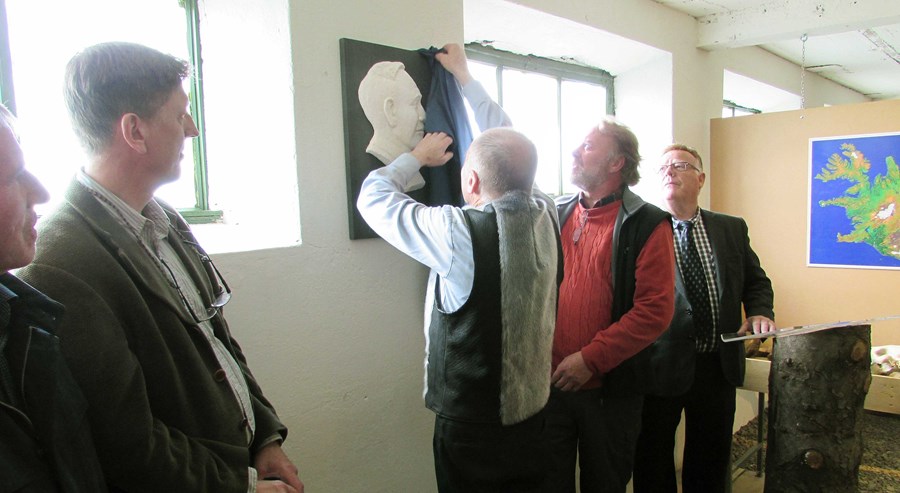 Gunnar Jónasson afhjúpar, með tilsjón listamannsins, lágmyndina af Guðmundi Jónssyni fyrir hönd Hvanneyringa 1963. Jón Hólm Stefánsson, talsmaður gefenda, lengst t.h. og Björn Þorsteinsson rektor, lengst t.v.