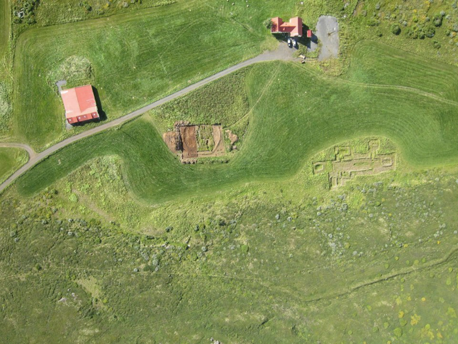 Heimatún Hofstaða. Bæjarhúsið efst til hægri og útihús til vinstri. Uppgrafinn víkingaaldarskáli sést neðanvert til hægri og miðaldakirkjugarður til vinstri