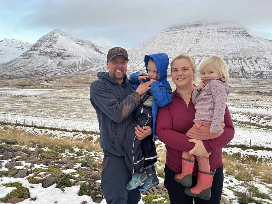 Gunnar Guðmundsson og Auður Arnarsdóttir ásamt börnum sínum, Hilmari og Margréti Adele. Nýendurræktuð tún og stórbrotin fjöll í baksýn.