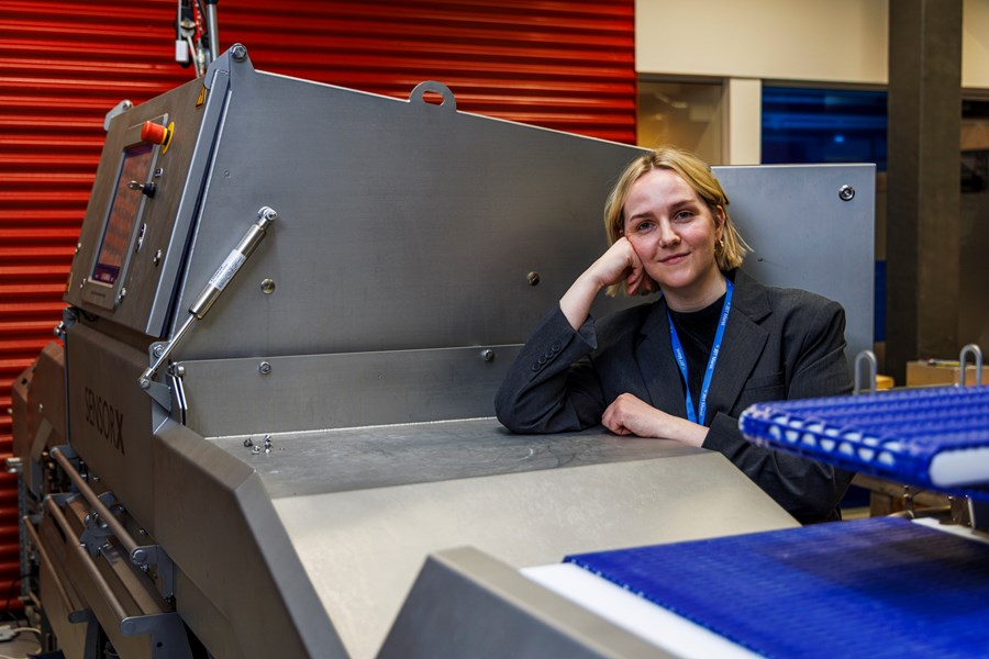 Nína Margrét Gísladóttir, vörustjóri SensorX hjá JBT Marel. Hér stendur hún við hlið SensorX kjúklingabeinaleitarvélar í vöruþróunarsmiðju í Austurhrauni í Garðabæ. Met var sett í sölu SensorX véla í fyrra, en þær hafa verið í tæp 20 ár á markaði. Mynd tekin í febrúar. 