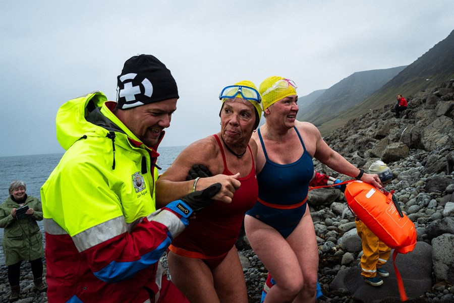 Jón Ágúst, stjórnarmaður í Sæunnarsundi, leggur ætíð gjörva hönd á undirbúning og öryggisgæslu og leiðir hann hér þaulvanar Sæunnarsundskonur, Magneu Hilmarsdóttur og Ernu Héðinsdóttur í öruggt skjól eftir sundið yfir fjörðinn.